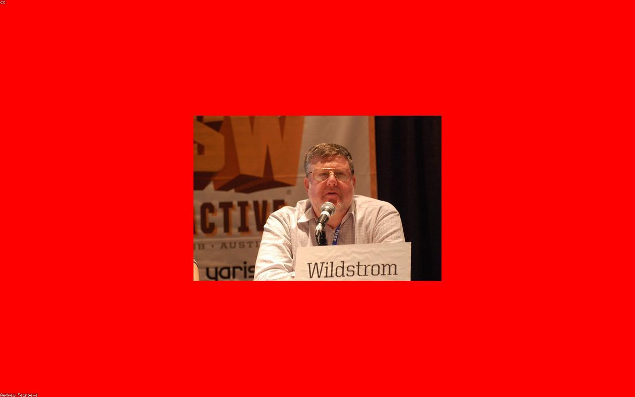 A professional male keynote speaker addressing an audience in a conference setting